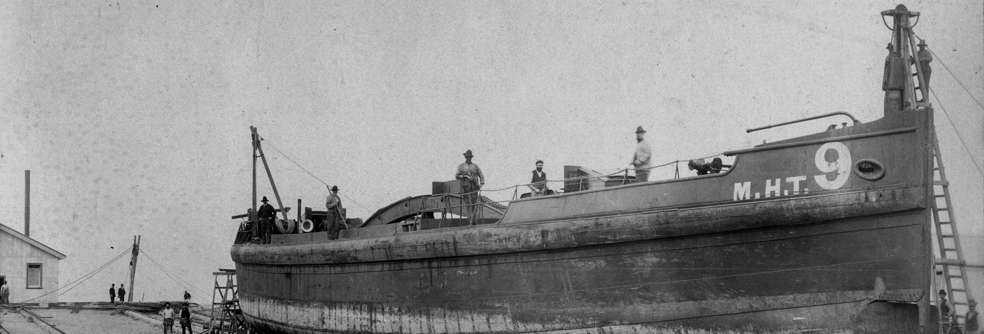 Black and white photo of a ship with crew